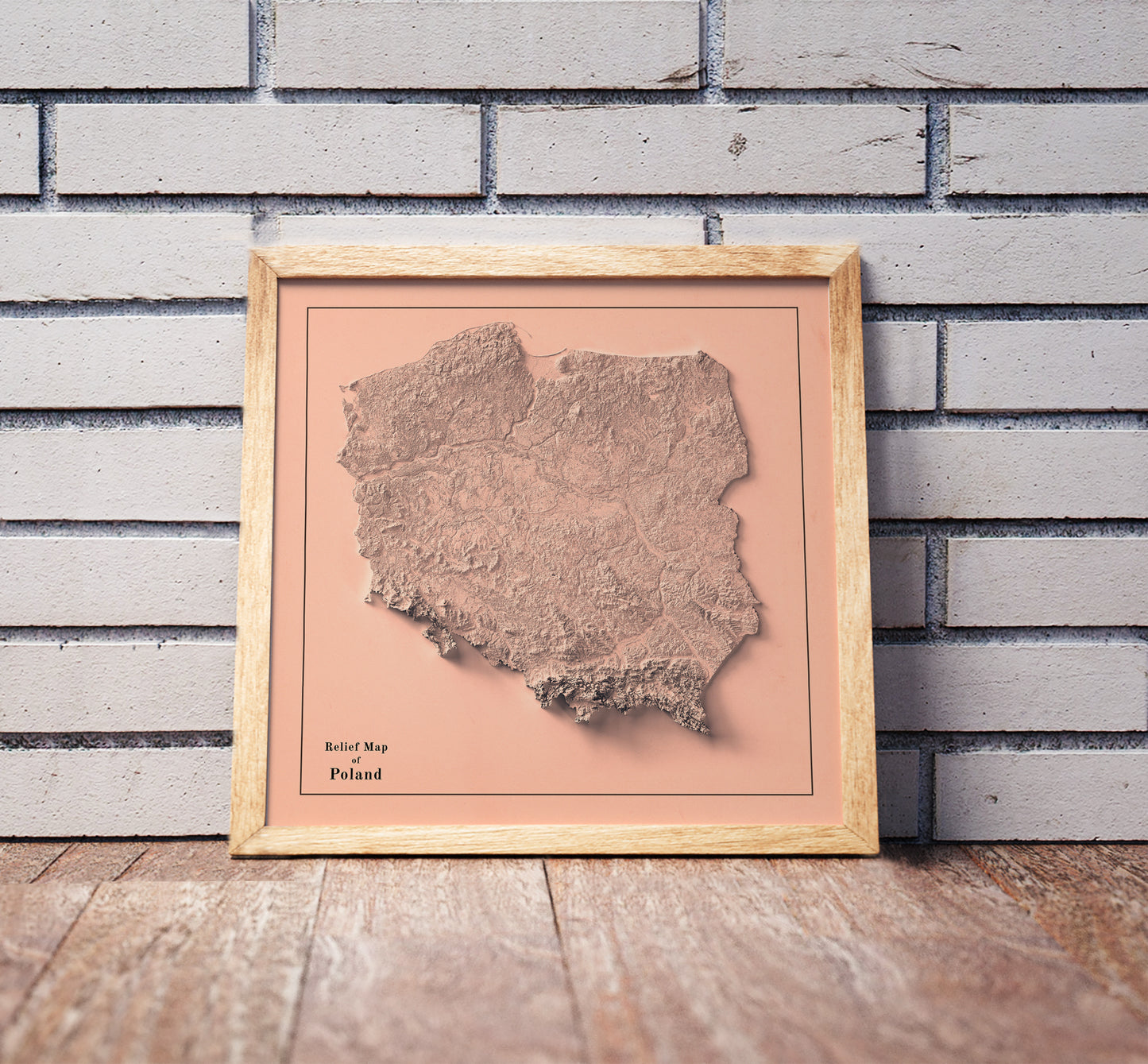 Vintage Poland shaded relief map in a wooden frame. Realistic terrain art print for home decor, displayed against a brick wall