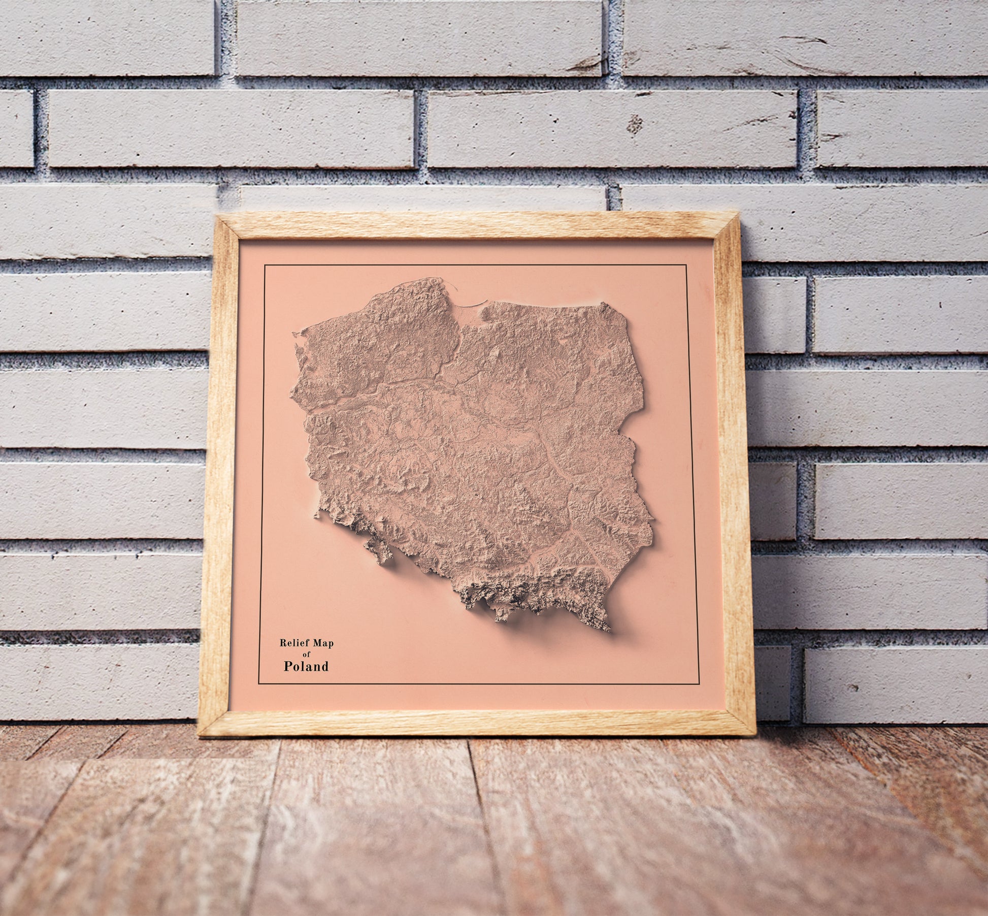 Vintage Poland shaded relief map in a wooden frame. Realistic terrain art print for home decor, displayed against a brick wall