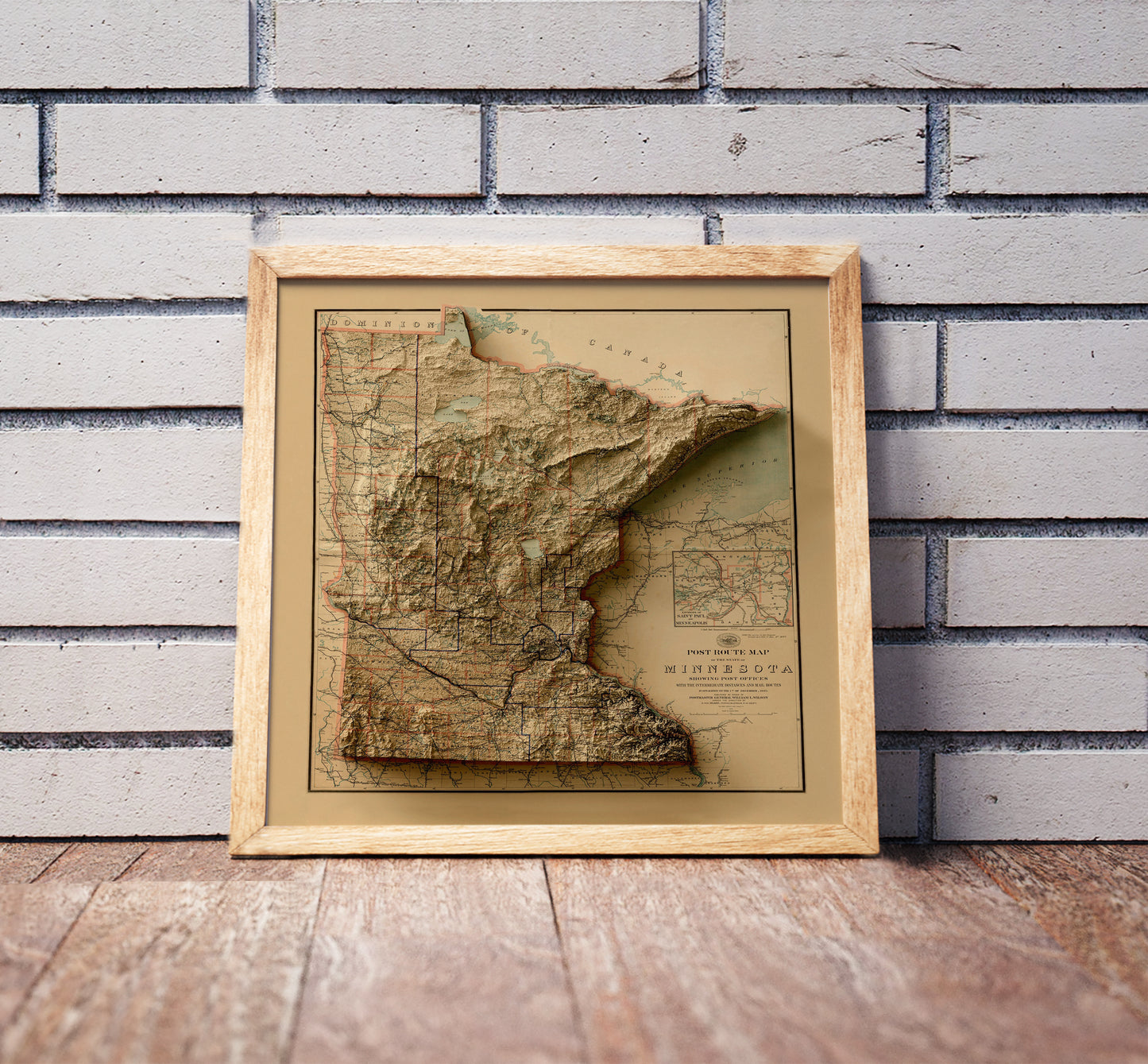 Vintage Minnesota shaded relief map in a wooden frame. Realistic terrain art print for home decor, displayed against a brick wall