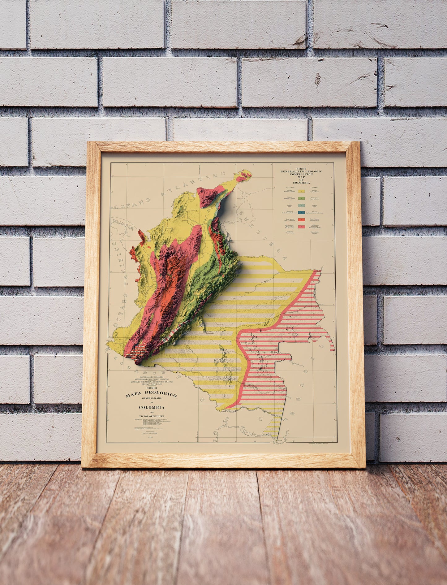 Vintage Colombia shaded relief map in a wooden frame. Realistic terrain art print for home decor, displayed against a brick wall