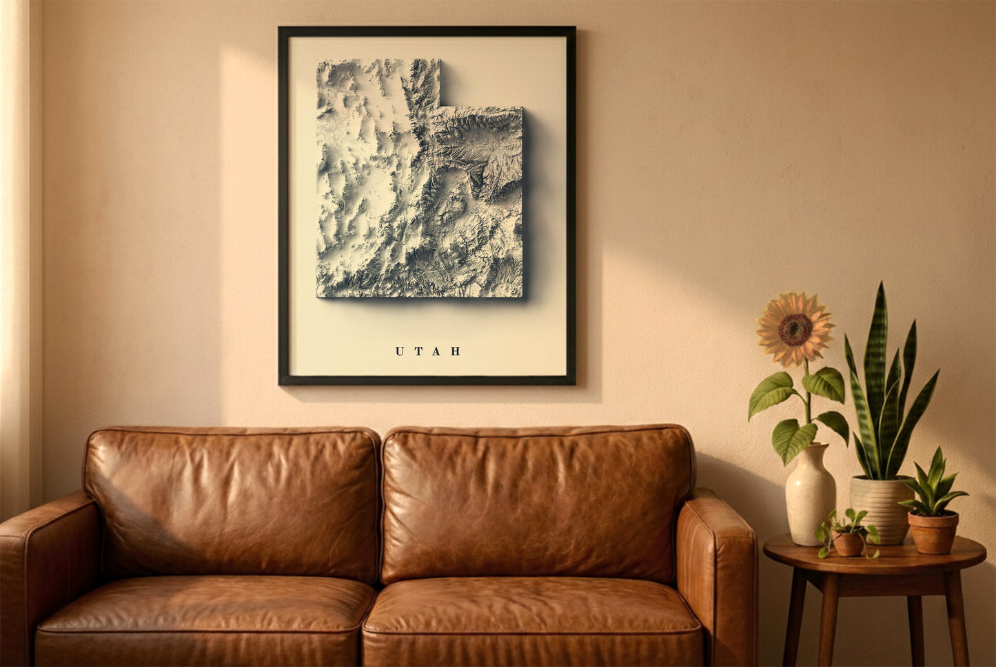 Utah relief map in a black frame above a brown leather sofa. Boho living room with warm sunlight, sunflower, and indoor plants on a wooden side table