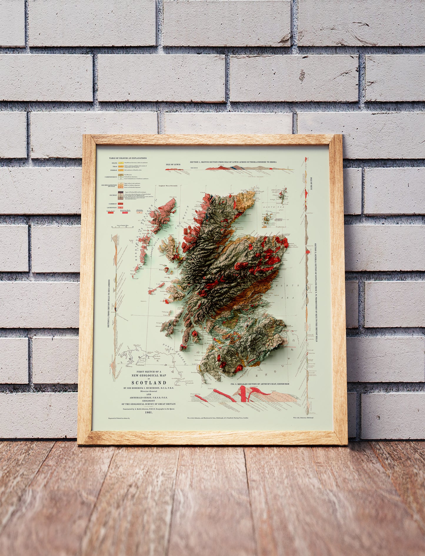 Vintage Scotland haded relief map in a wooden frame. Realistic terrain art print for home decor, displayed against a brick wall