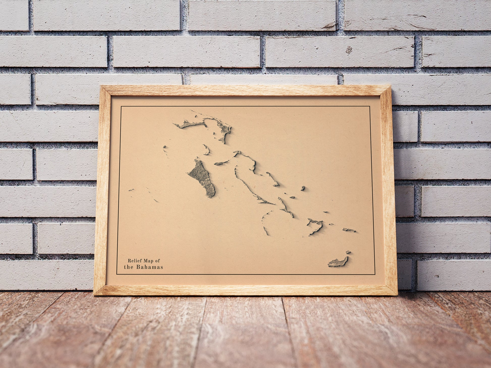 Vintage Bahamas shaded relief map in a wooden frame. Realistic terrain art print for home decor, displayed against a brick wall