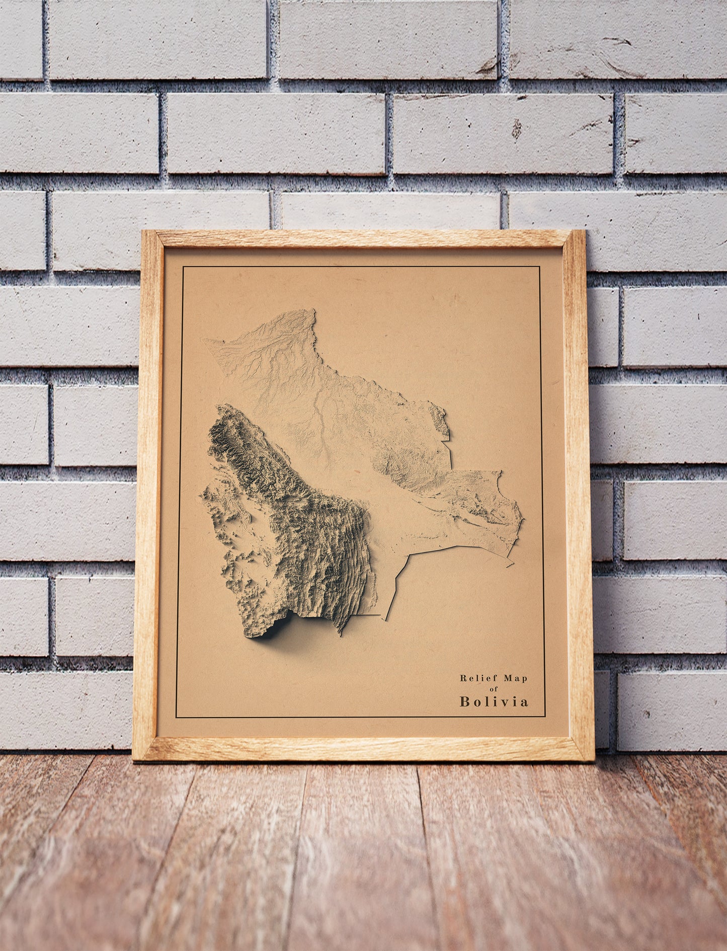 Vintage Bolivia shaded relief map in a wooden frame. Realistic terrain art print for home decor, displayed against a brick wall