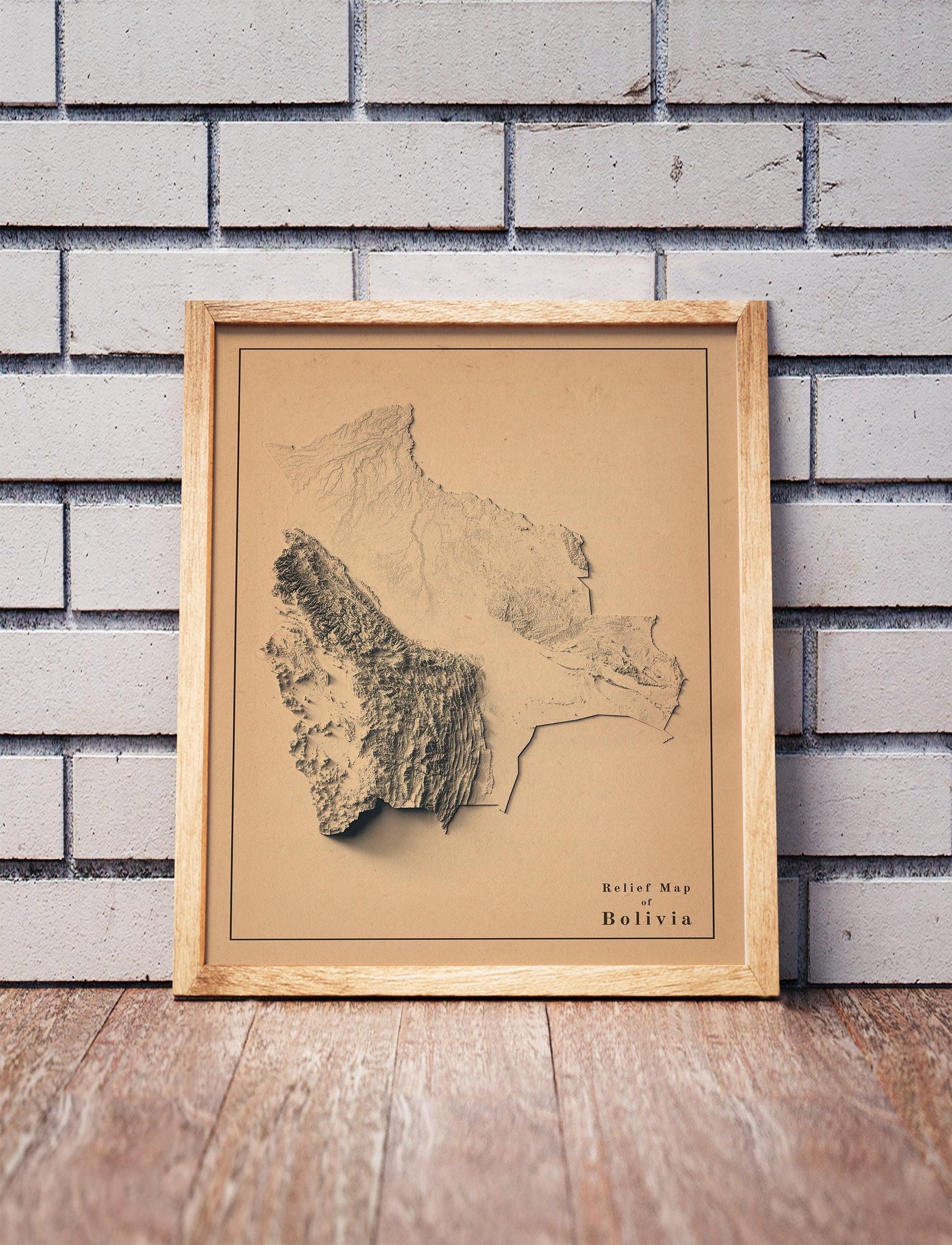 Vintage Bolivia shaded relief map in a wooden frame. Realistic terrain art print for home decor, displayed against a brick wall