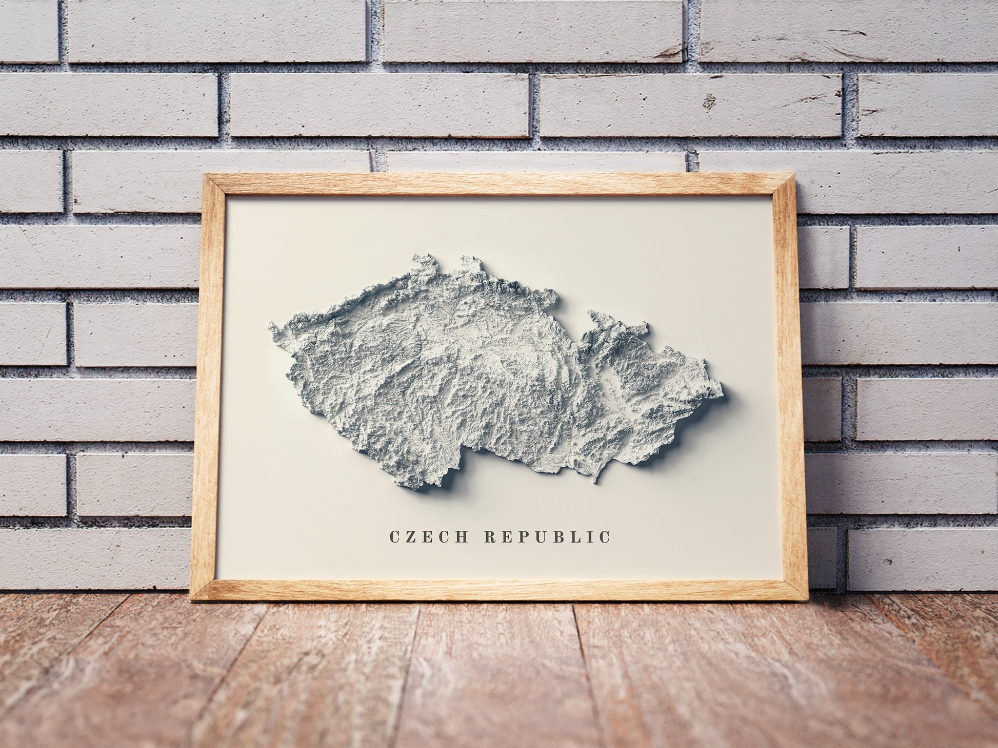 Czech Republic shaded relief map in a wooden frame. Realistic terrain art print for home decor, displayed against a brick wall