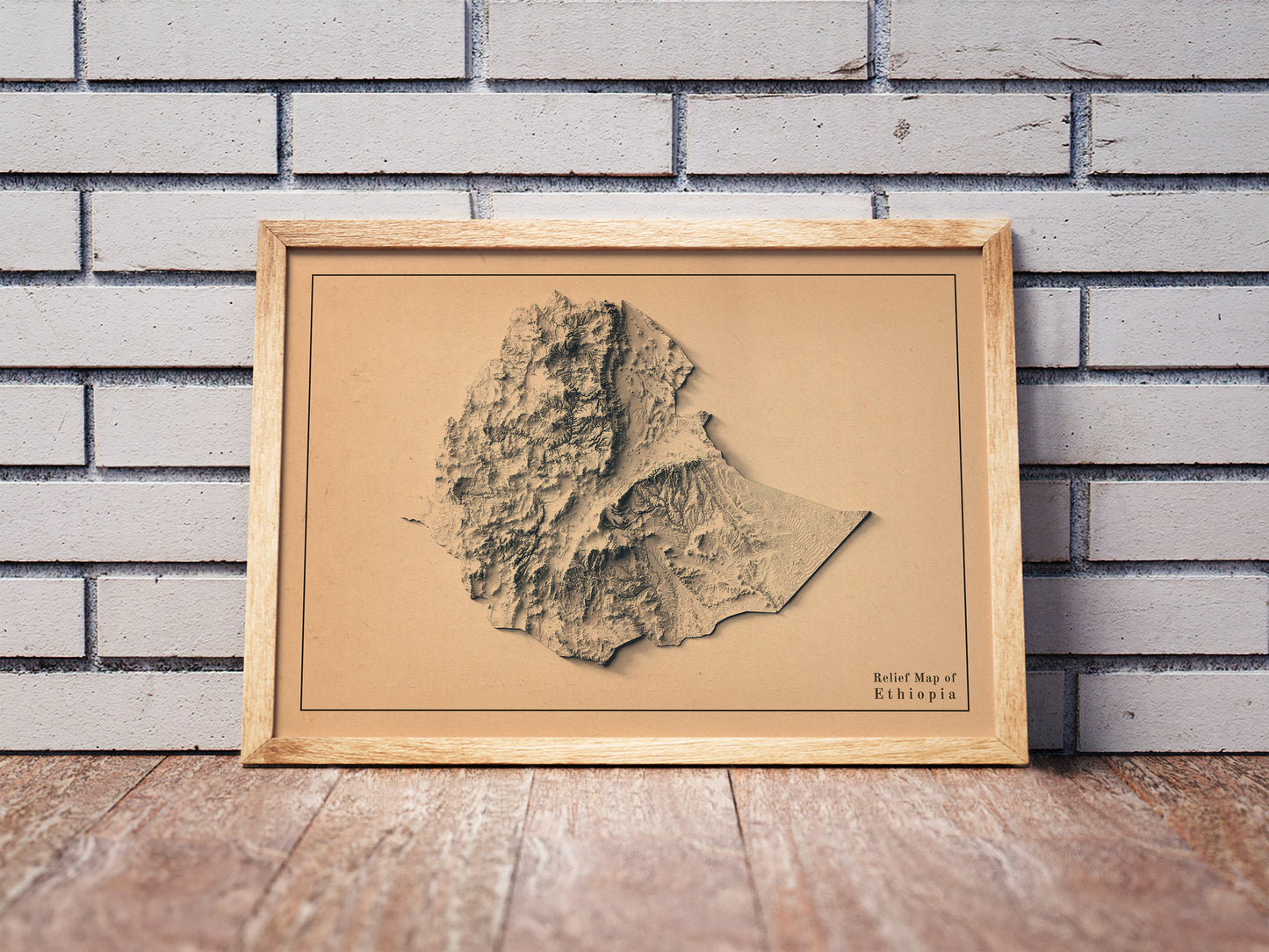 Vintage Ethiopia shaded relief map in a wooden frame. Realistic terrain art print for home decor, displayed against a brick wall