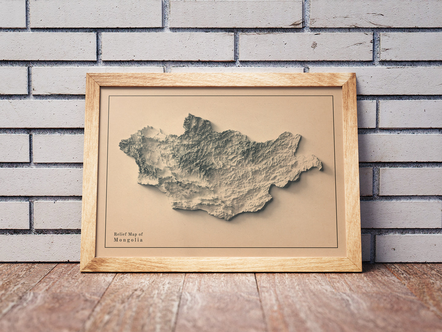 Vintage Mongolia shaded relief map in a wooden frame. Realistic terrain art print for home decor, displayed against a brick wall