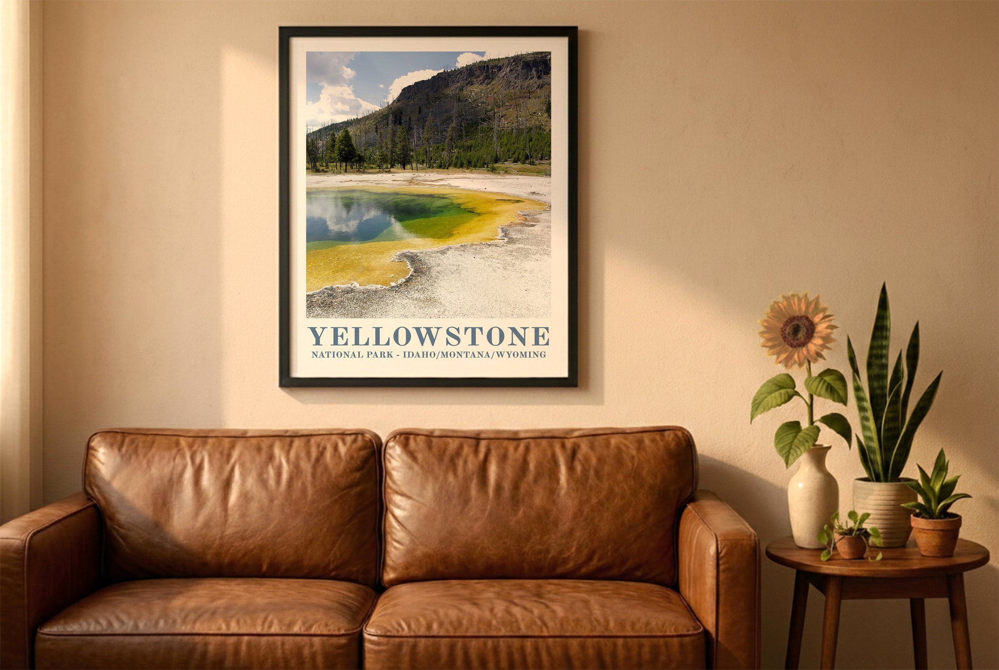 Yellowstone poster in a black frame above a brown leather sofa. Boho living room with warm sunlight, sunflower, and indoor plants on a wooden side table