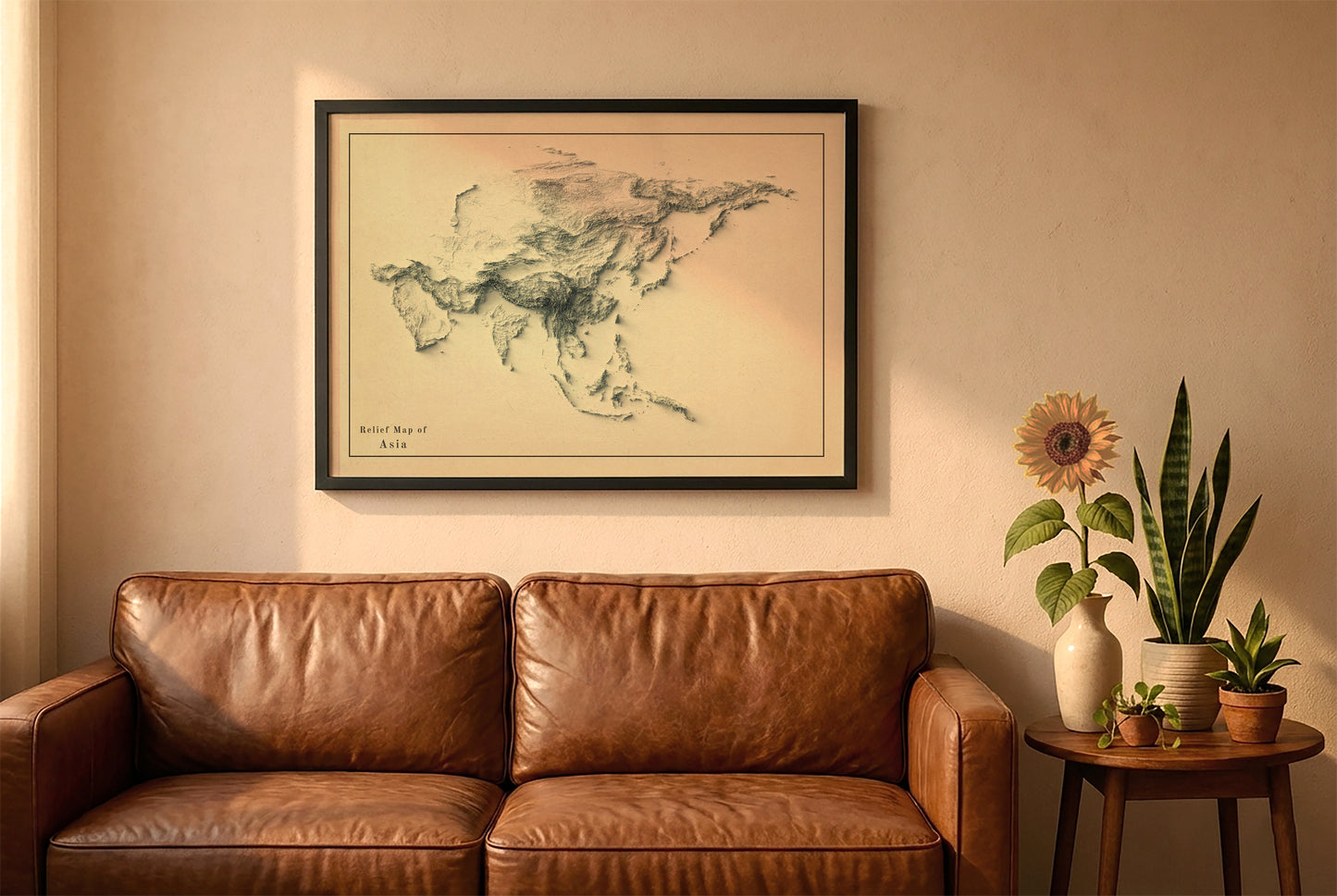 Asia vintage relief map in a black frame above a brown leather sofa. Boho living room with warm sunlight, sunflower, and indoor plants on a wooden side table