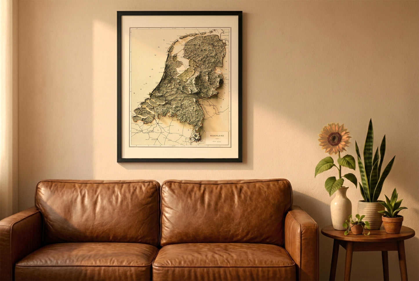 Netherlands vintage relief map in a black frame above a brown leather sofa. Boho living room with warm sunlight, sunflower, and indoor plants on a wooden side table