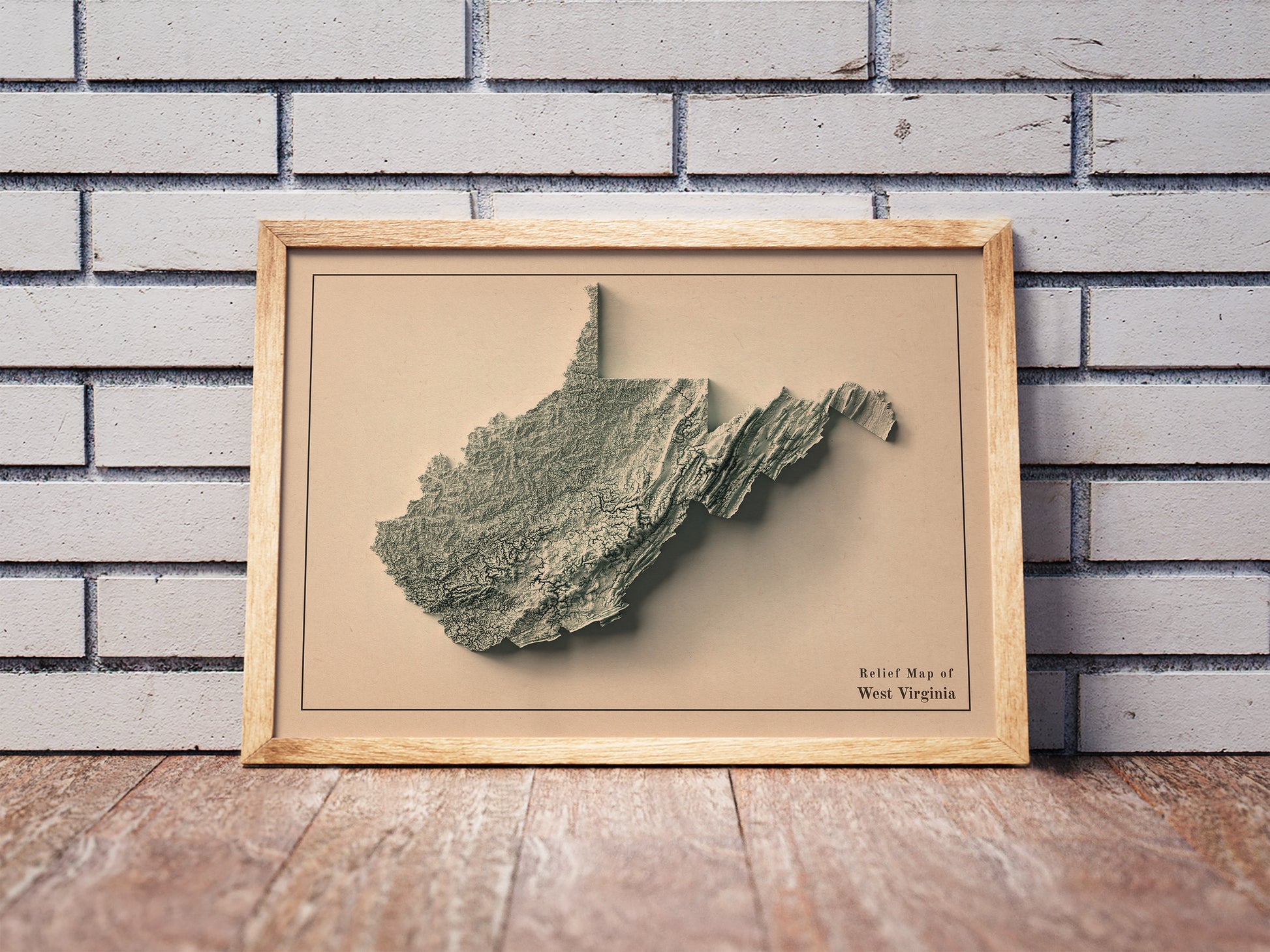Vintage West Virginia shaded relief map in a wooden frame. Realistic terrain art print for home decor, displayed against a brick wall