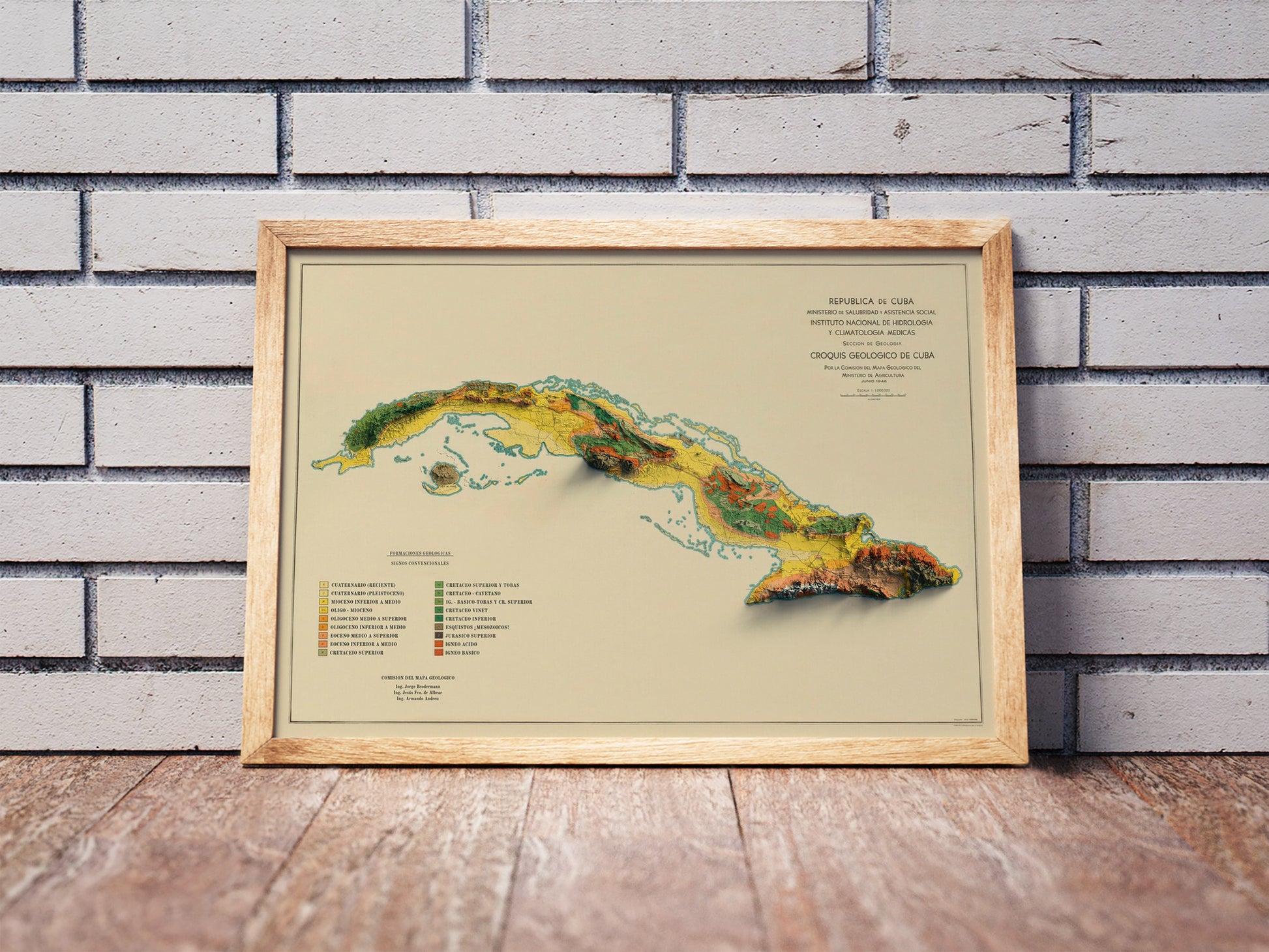 Vintage Cuba shaded relief map in a wooden frame. Realistic terrain art print for home decor, displayed against a brick wall