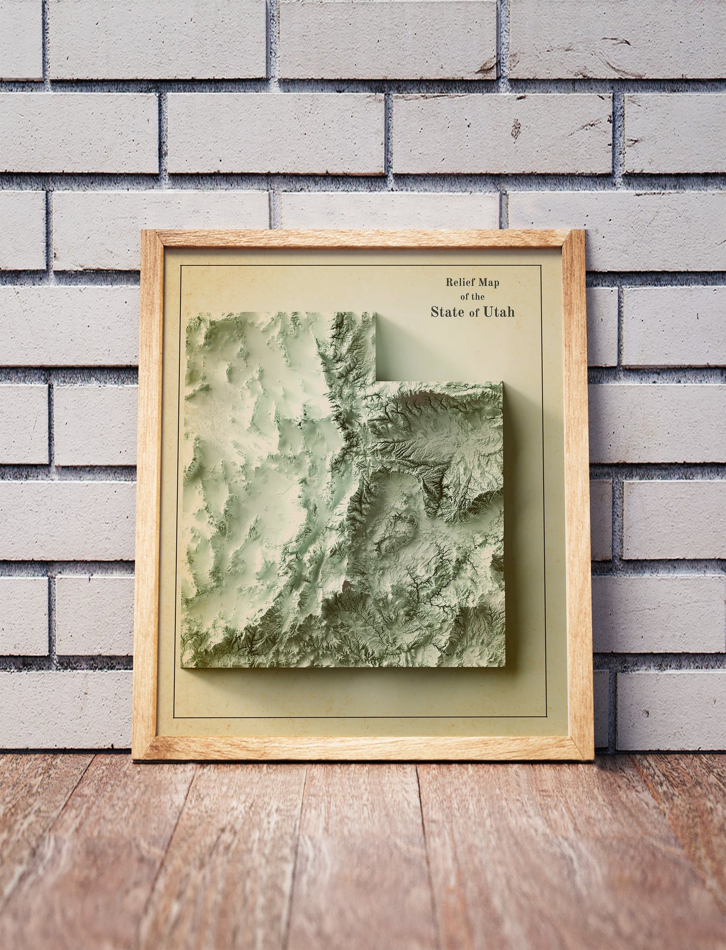 Vintage utah shaded relief map in a wooden frame. Realistic terrain art print for home decor, displayed against a brick wall
