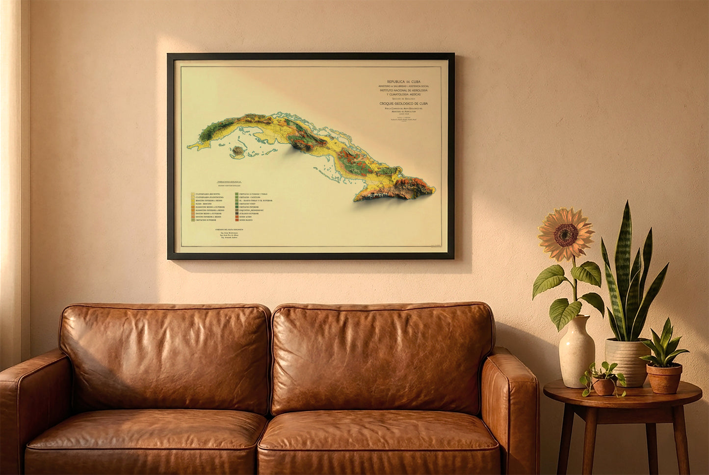 Cuba vintage relief map in a black frame above a brown leather sofa. Boho living room with warm sunlight, sunflower, and indoor plants on a wooden side table