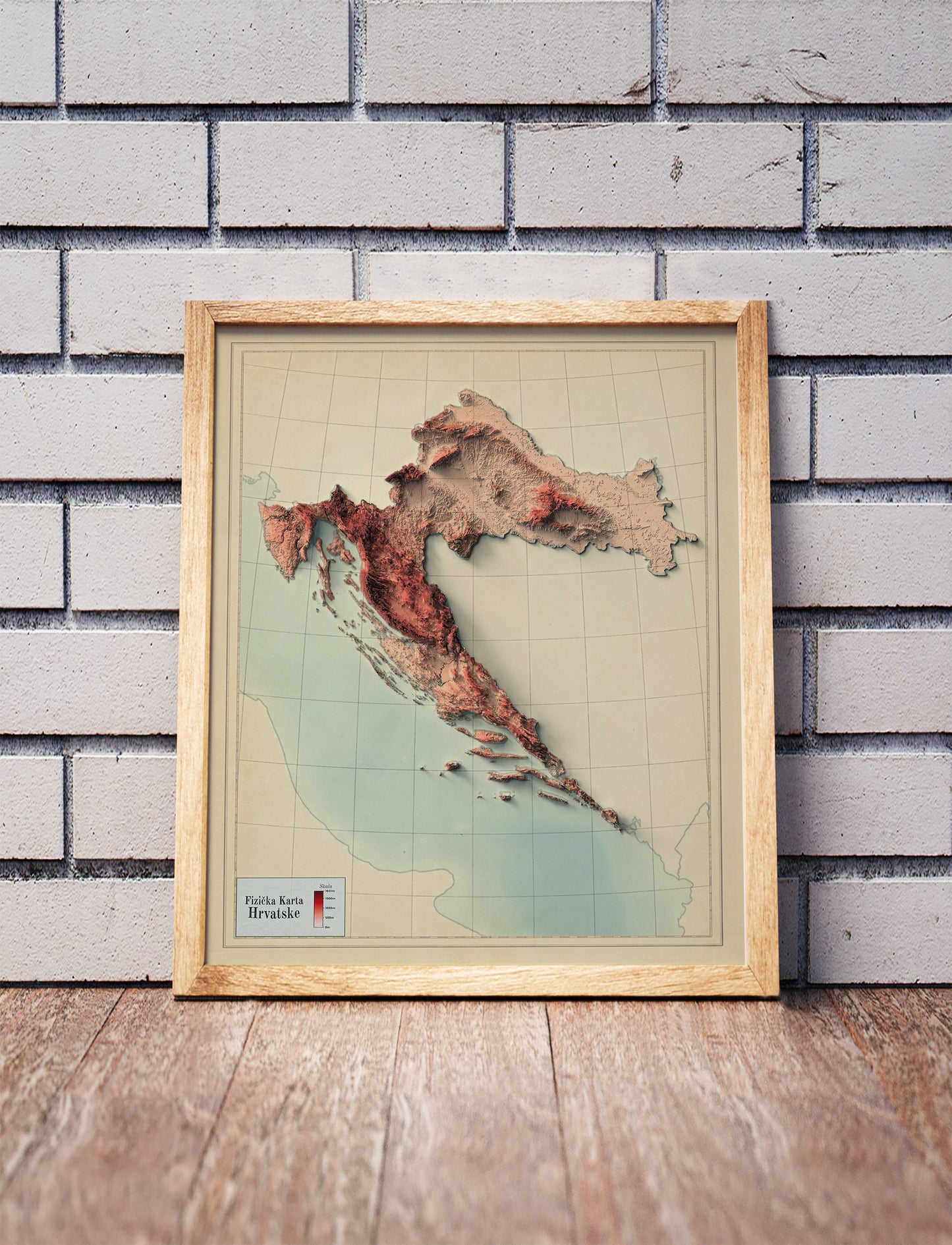 Vintage Croatia shaded relief map in a wooden frame. Realistic terrain art print for home decor, displayed against a brick wall