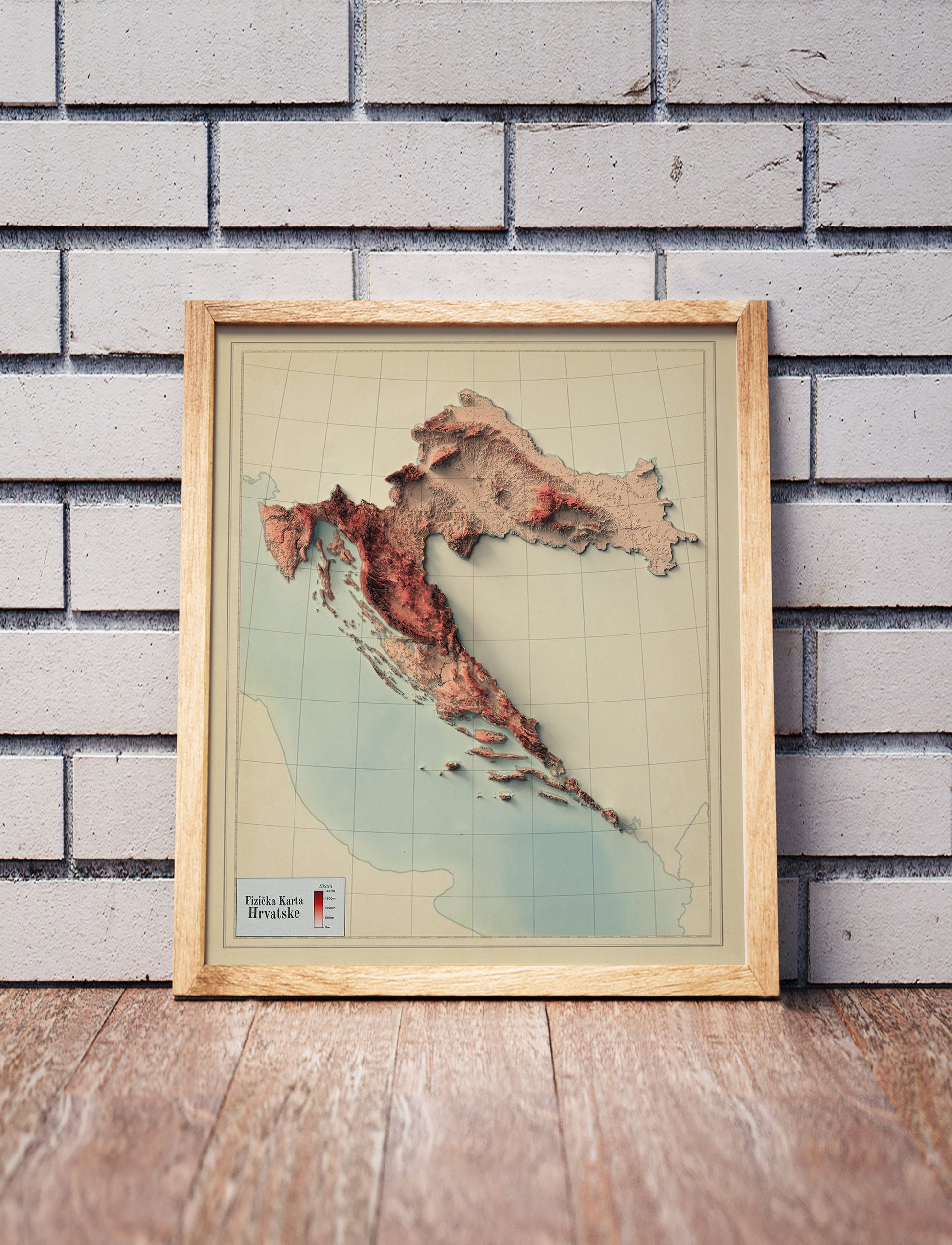 Vintage Croatia shaded relief map in a wooden frame. Realistic terrain art print for home decor, displayed against a brick wall