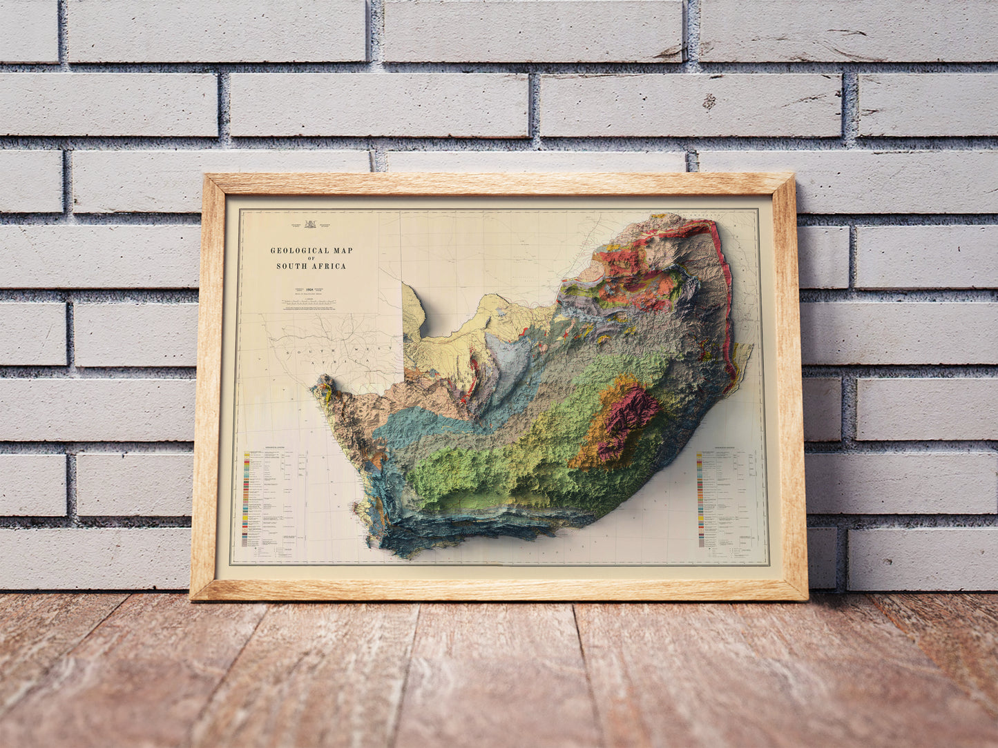 Vintage South Africa shaded relief map in a wooden frame. Realistic terrain art print for home decor, displayed against a brick wall