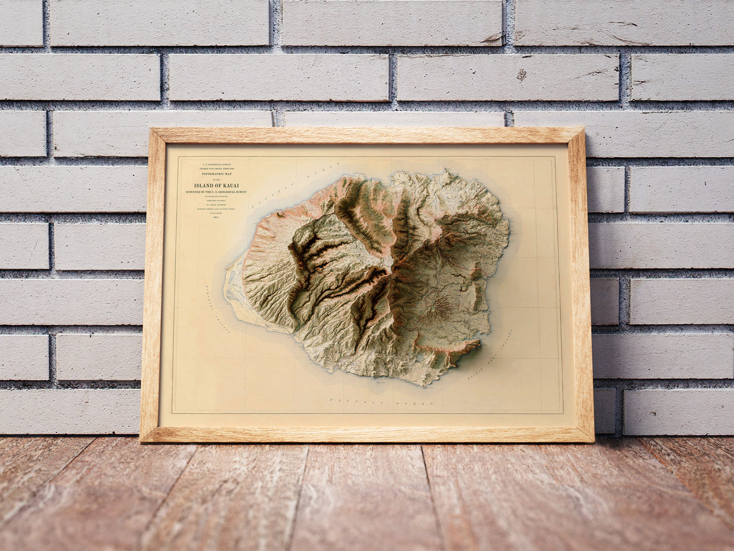 Vintage Kauai, Hawaii, shaded relief map in a wooden frame. Realistic terrain art print for home decor, displayed against a brick wall