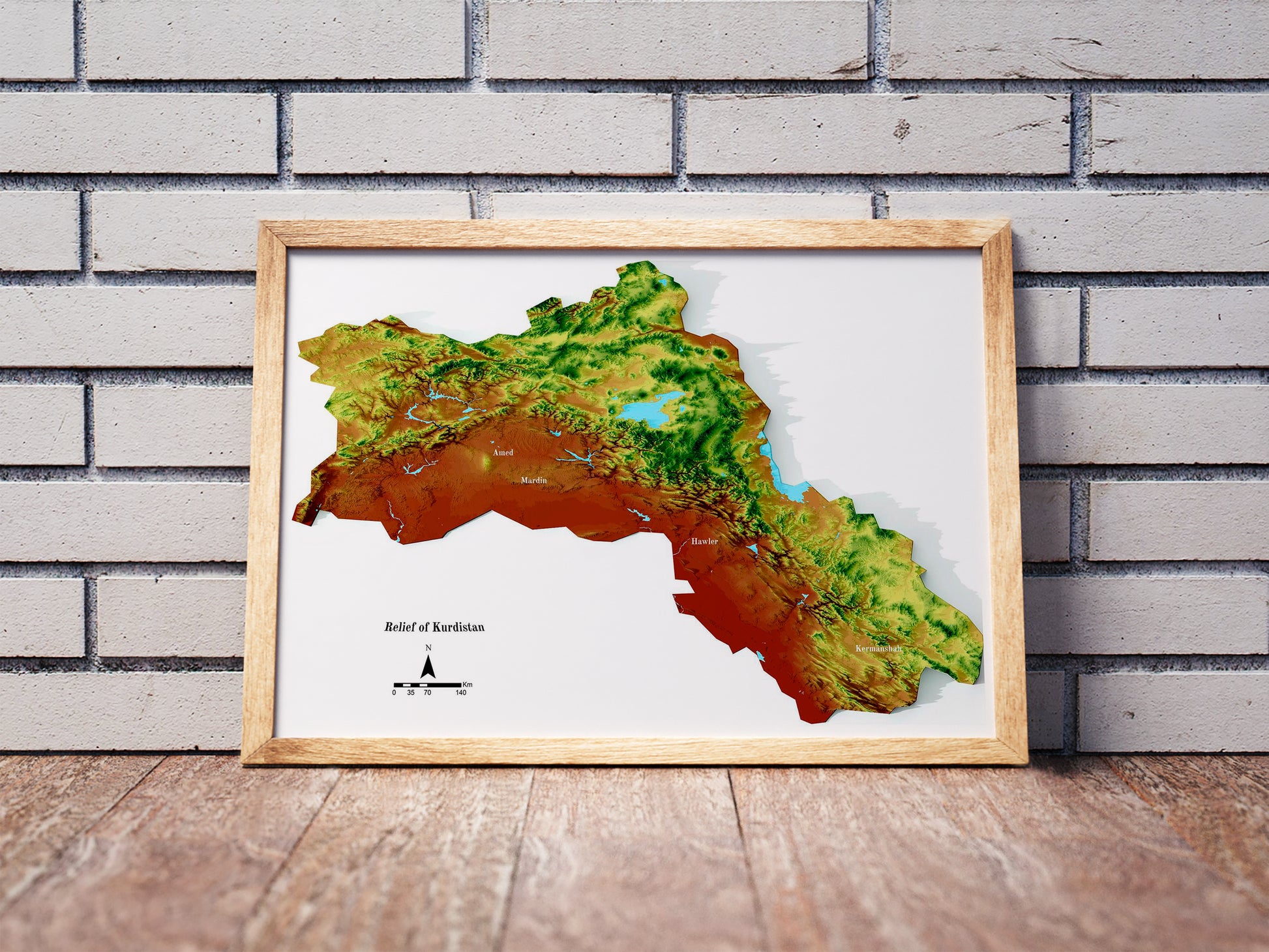 Vintage Kurdistan shaded relief map in a wooden frame. Realistic terrain art print for home decor, displayed against a brick wall