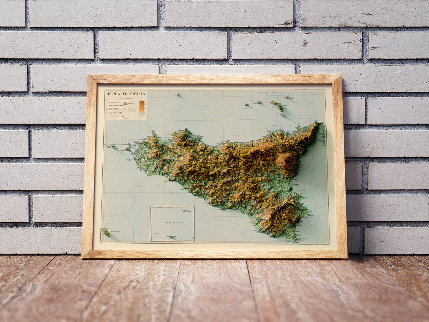 Vintage Sicily, Italy, shaded relief map in a wooden frame. Realistic terrain art print for home decor, displayed against a brick wall
