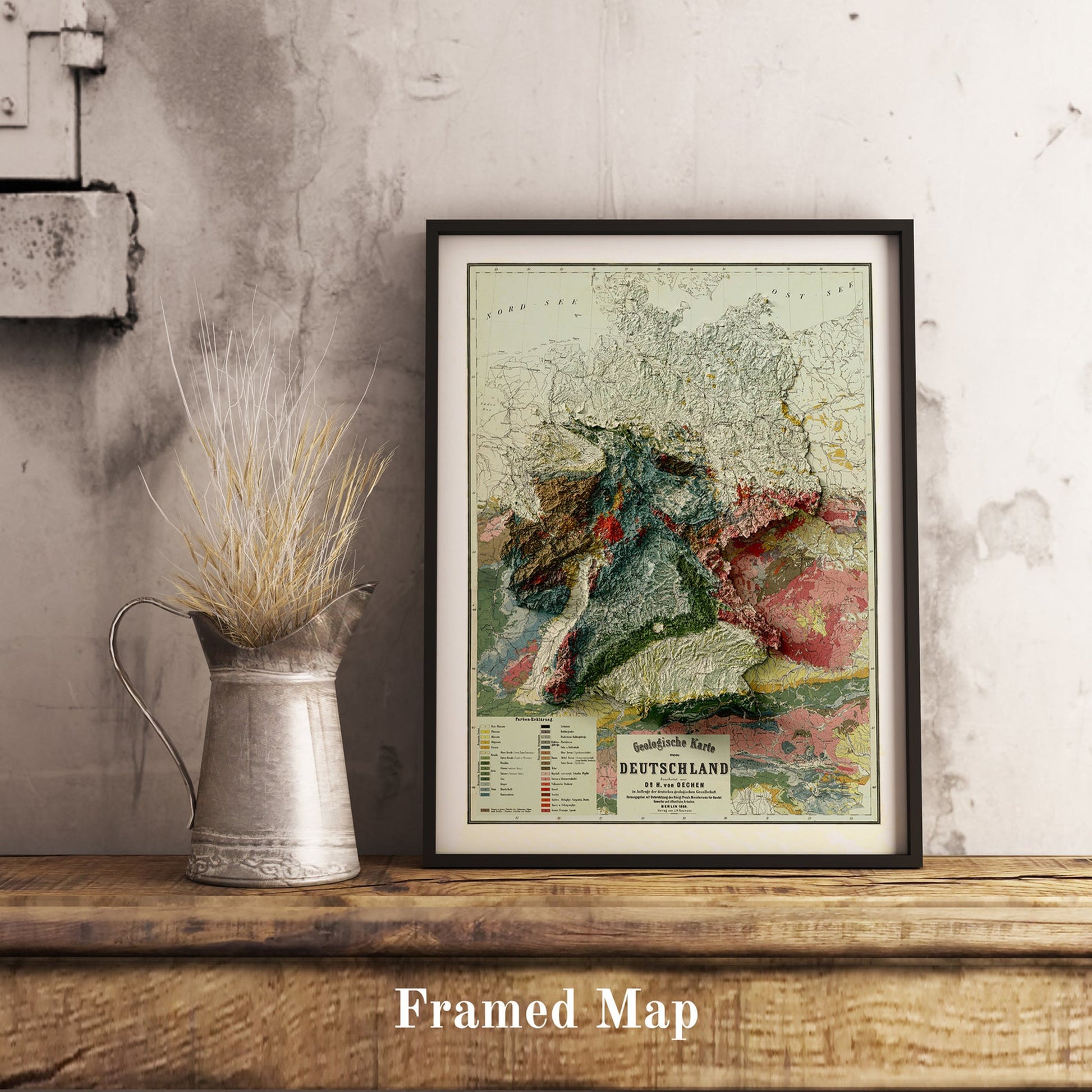 Vintage Germany shaded relief map in black frame. Realistic terrain art print for home decor, displayed on rustic wooden table