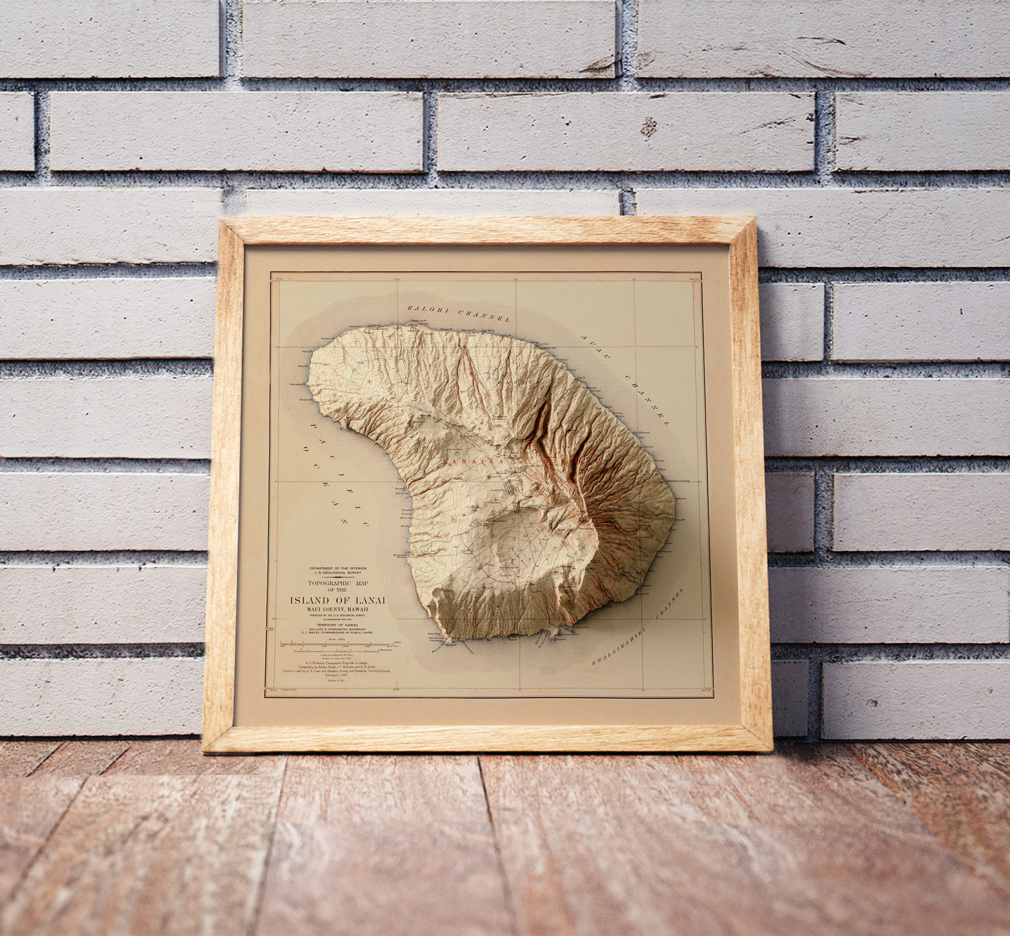 Vintage Lanai, Hawaii, shaded relief map in a wooden frame. Realistic terrain art print for home decor, displayed against a brick wall