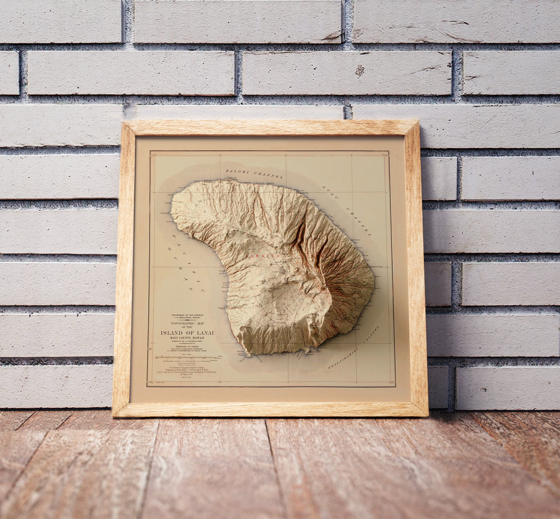 Vintage Lanai, Hawaii, shaded relief map in a wooden frame. Realistic terrain art print for home decor, displayed against a brick wall