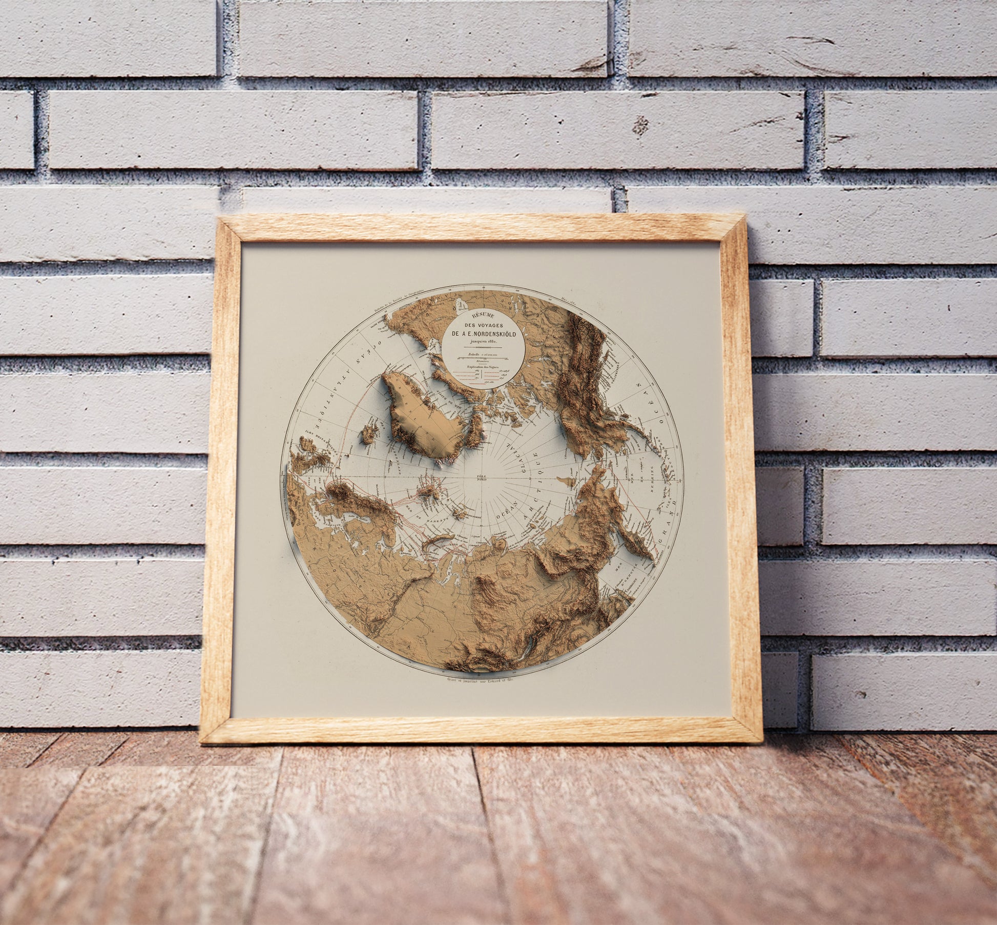 Vintage Arctic shaded relief map in a wooden frame. Realistic terrain art print for home decor, displayed against a brick wall