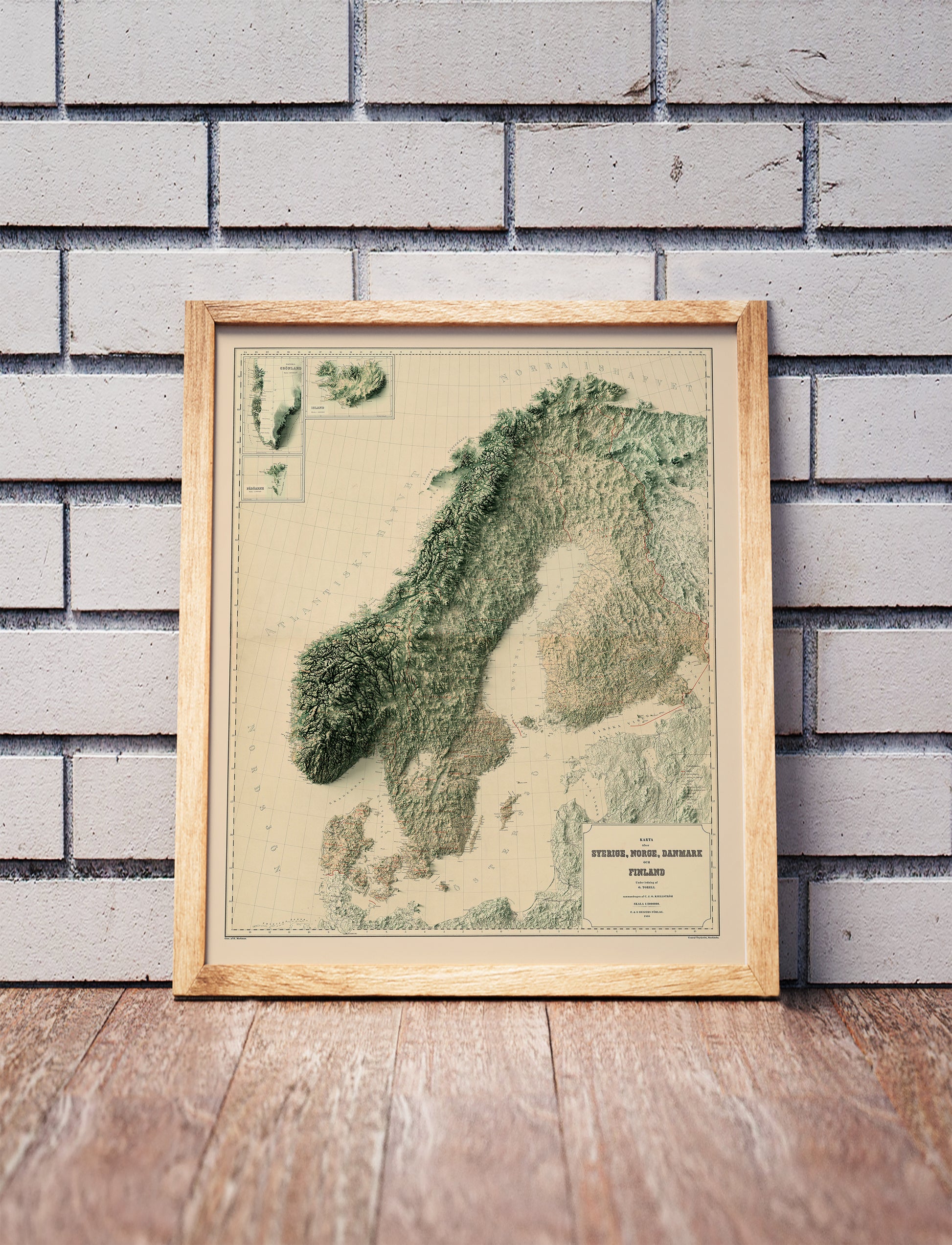 Vintage Scandinavia shaded relief map in a wooden frame. Realistic terrain art print for home decor, displayed against a brick wall