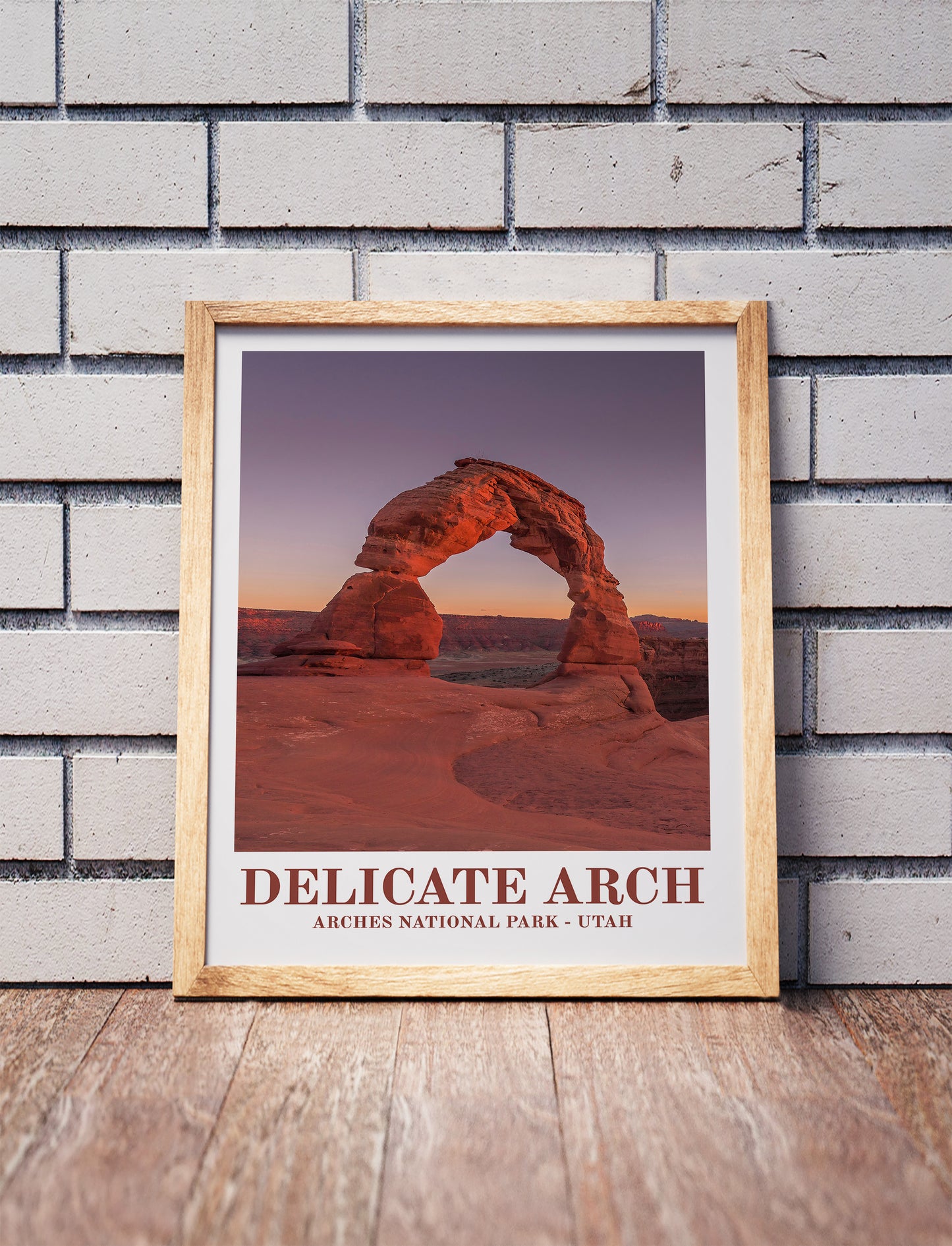 Vintage Arches National Park poster in a wooden frame. Realistic terrain art print for home decor, displayed against a brick wall